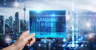 hand holding a blue screen with landing page written on it