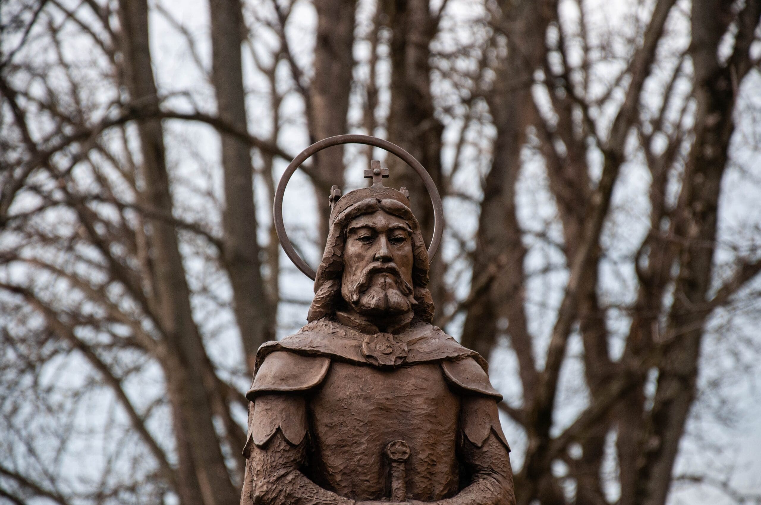 metal sculpture of a medieval ruler with a crown and sword 