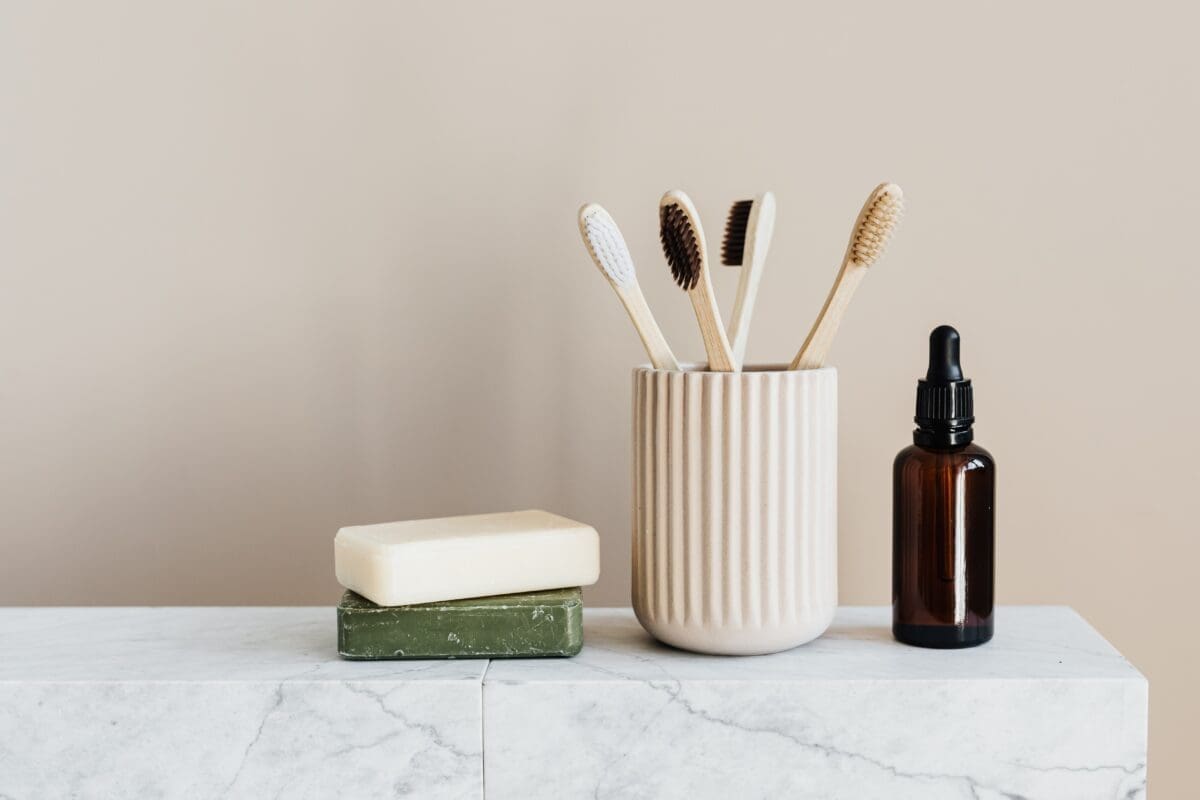 an image of two soap bars, four toothbrushes in a holder, and a dark glass bottle